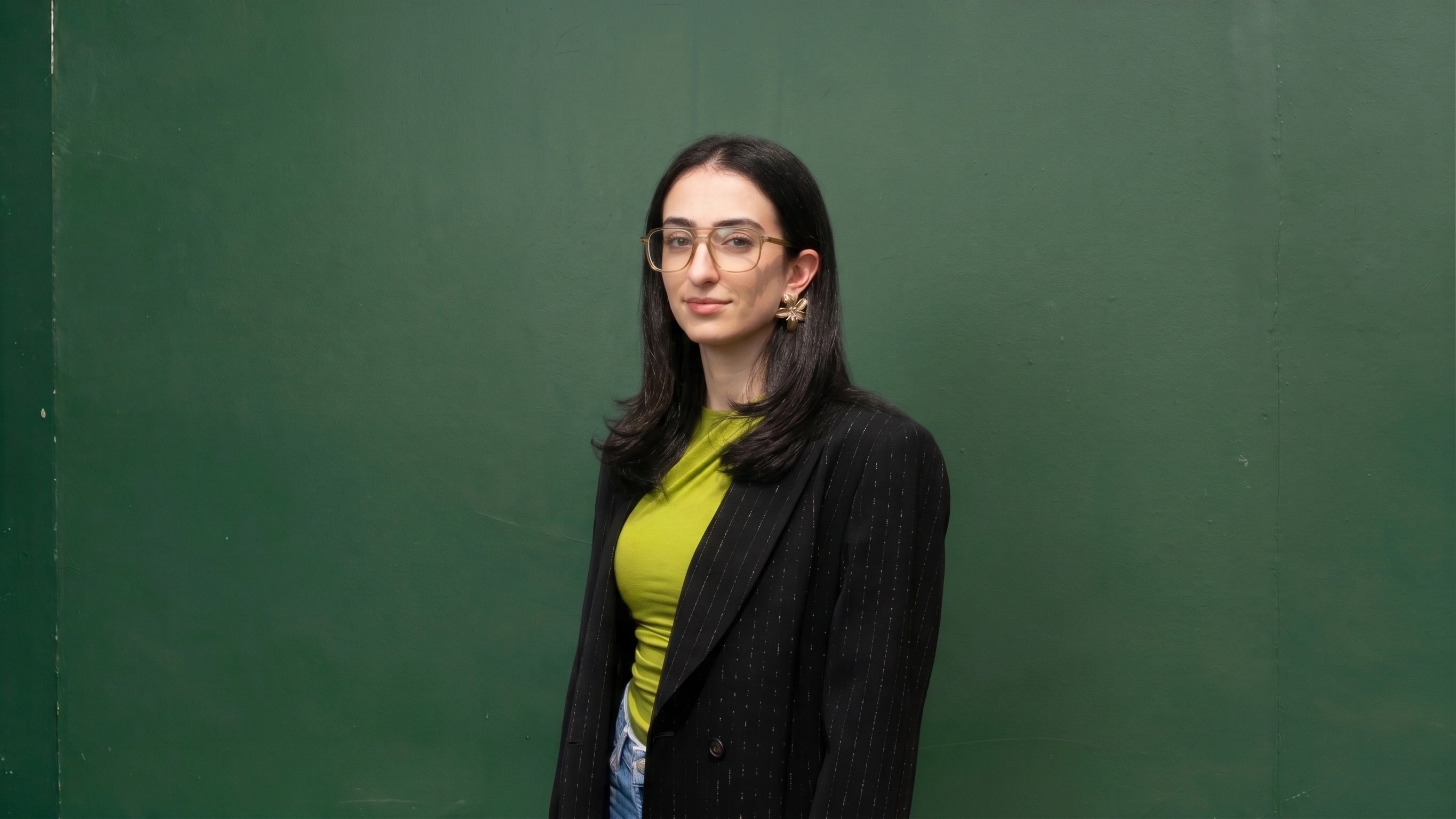 Arianna, VESTER co-founder, against a green concrete wall